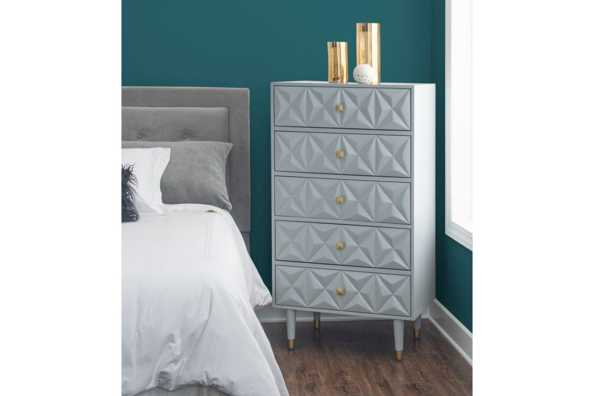 A gray chest of drawers with geometric three dimensional patterns on the drawers.